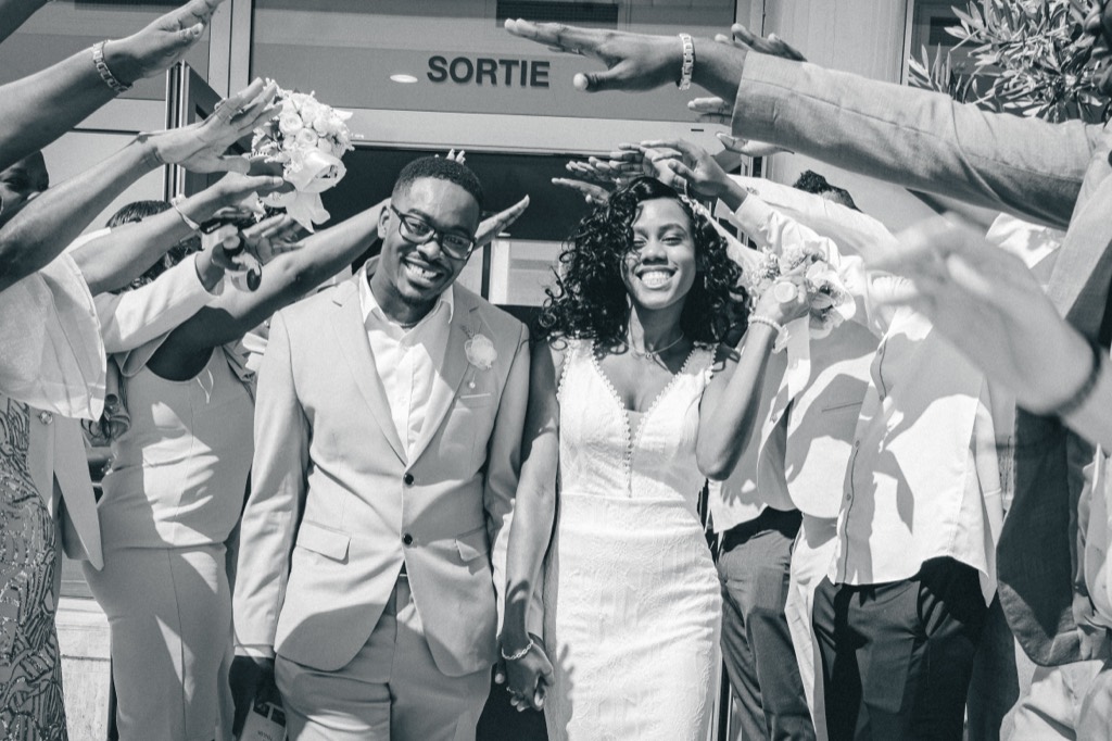 Sortie des mariés sous les applaudissements des familles, photographie en noir et blanc